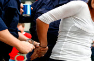 A person being arrested and placed in handcuffs